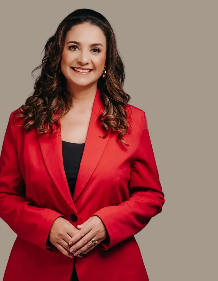 Dra. Vandrea Marques, de blazer vermelho, sorrindo